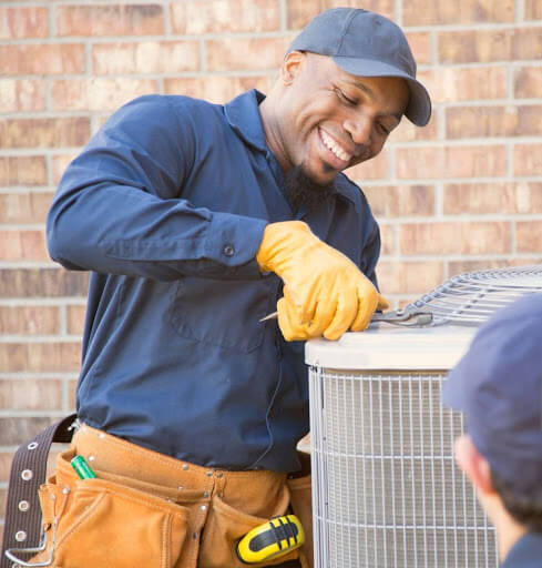 Mast Heating & Cooling technician smiling through a Hudsonville heat pump repair